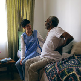 nurse assisting elderly man