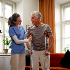 nurse assisting elderly man to walk