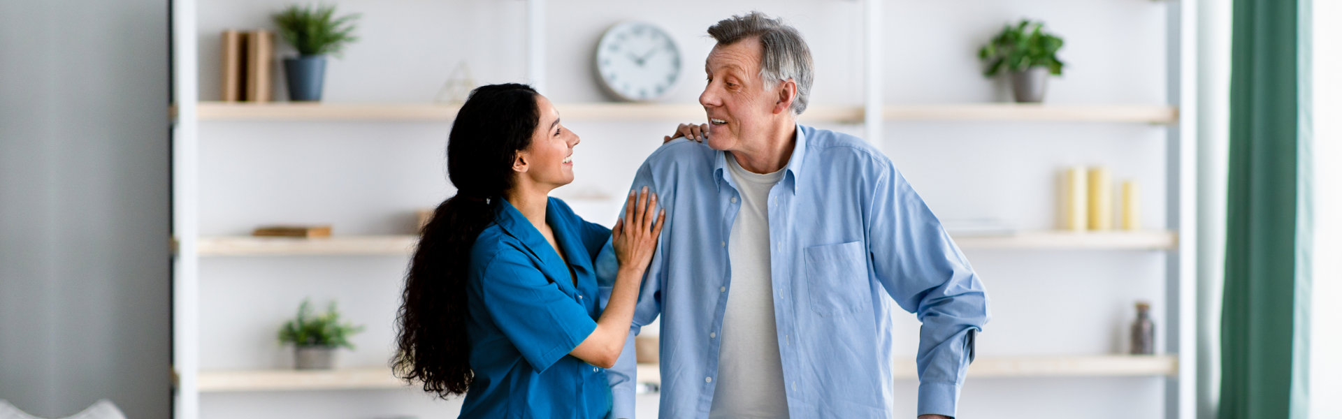 nurse assisting elderly man to walk