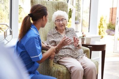 aide and elderly woman smiling