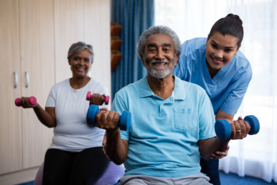 aide assisting elderly people in exercising